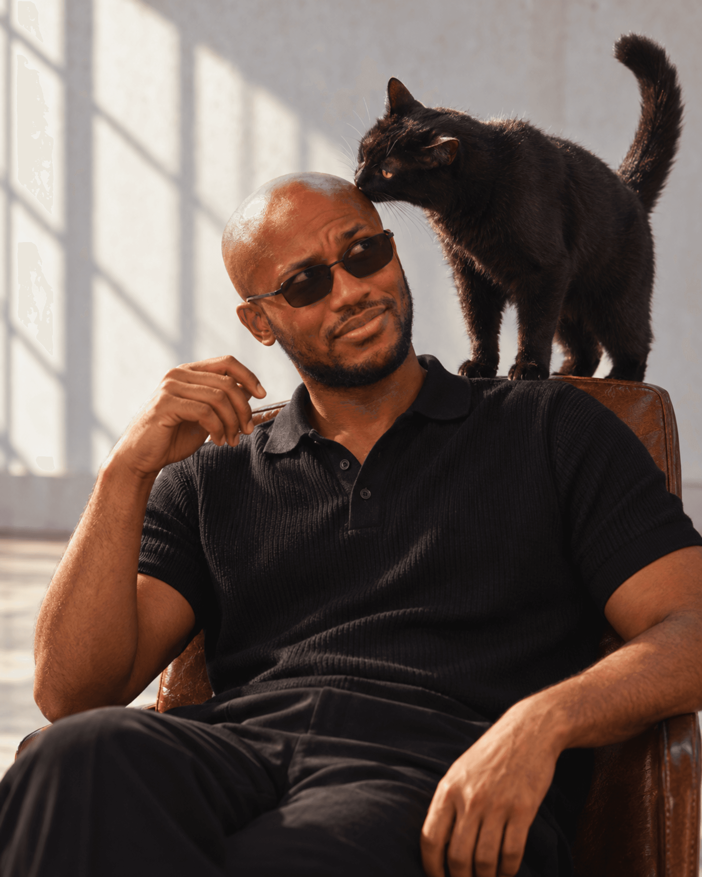 Muiz in black tailoring with a black cat, image 1