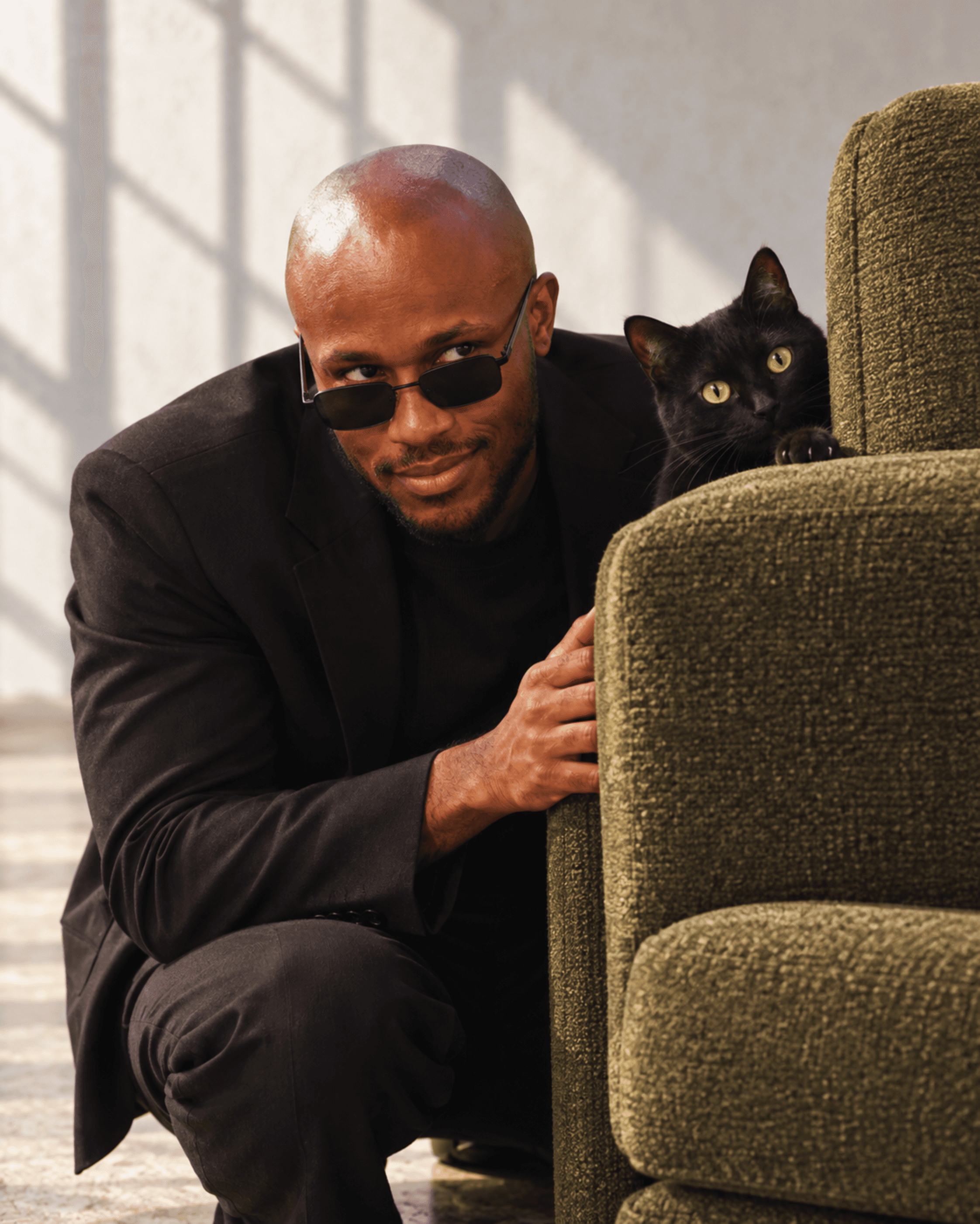 Muiz in black tailoring with a black cat, image 3