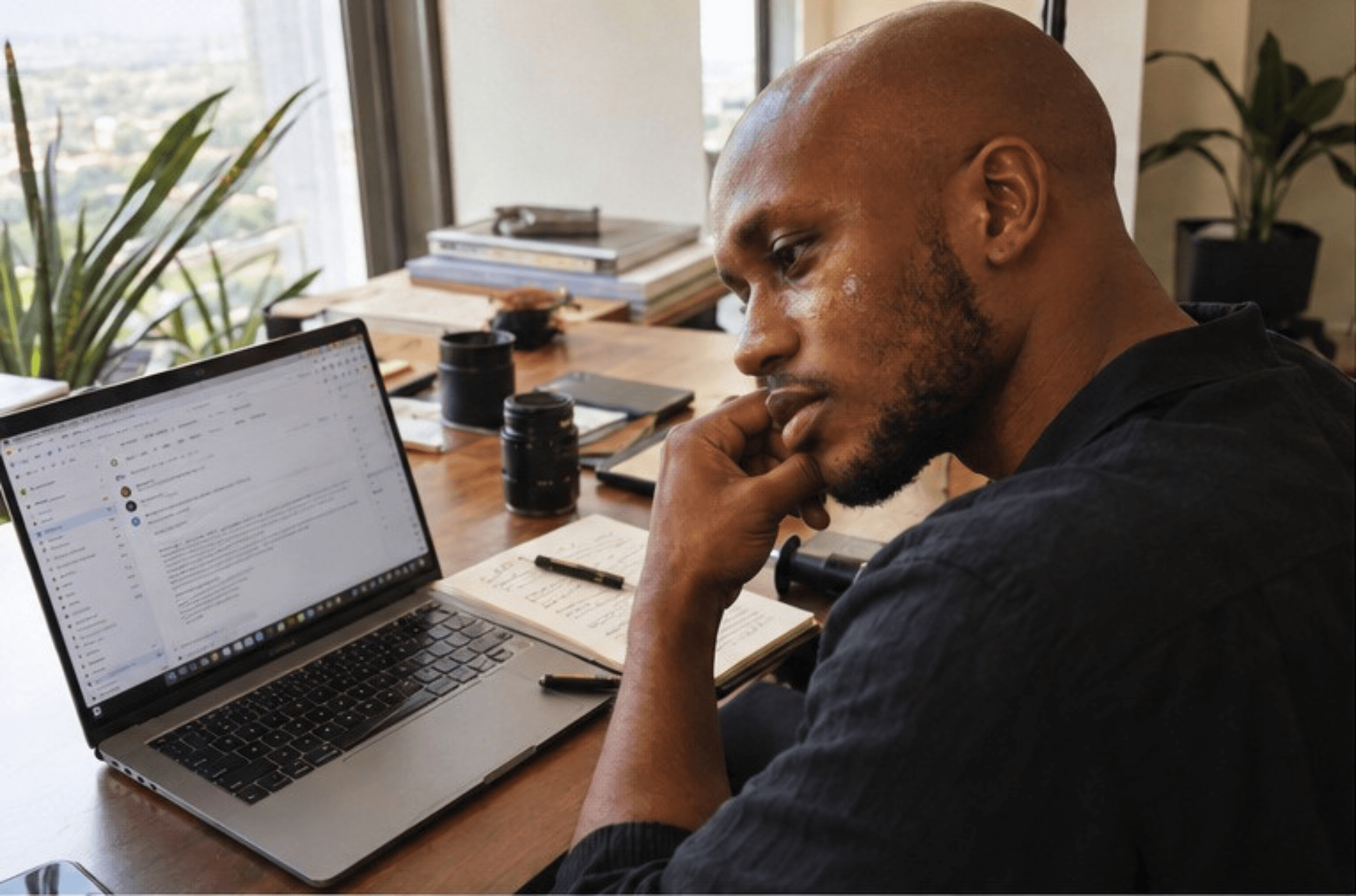 Male model reading a client brief on his laptop between setups on a shoot day